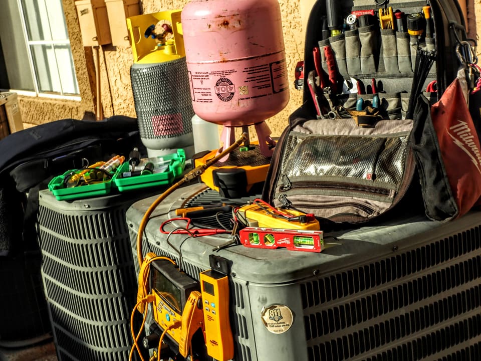 HVAC maintenance tools arranged on a residential outdoor air-conditioning unit
